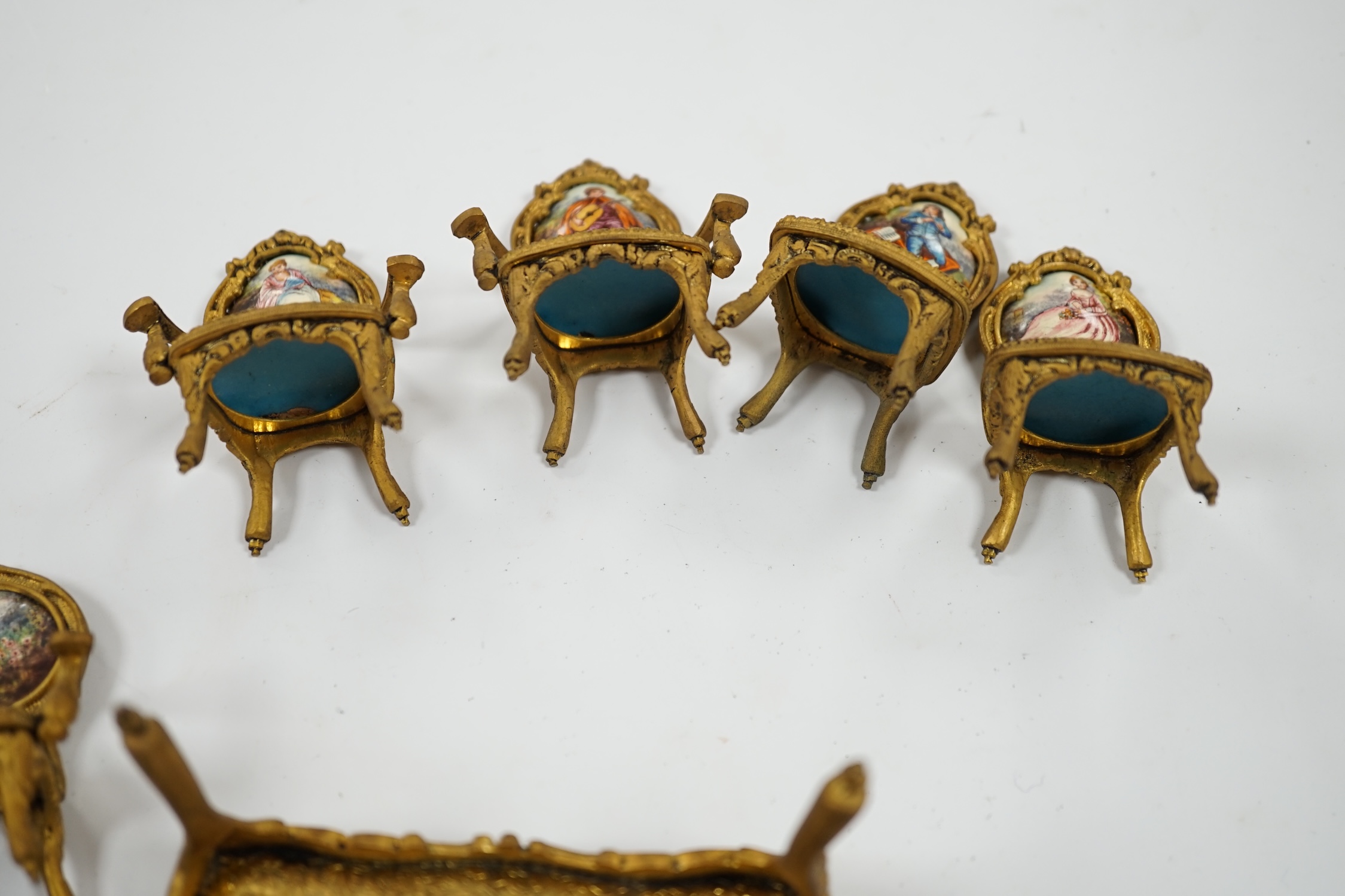 An early 20th century miniature enamel and gilt metal framed furniture set, possibly Austrian, largest 9cm wide. Condition - fair